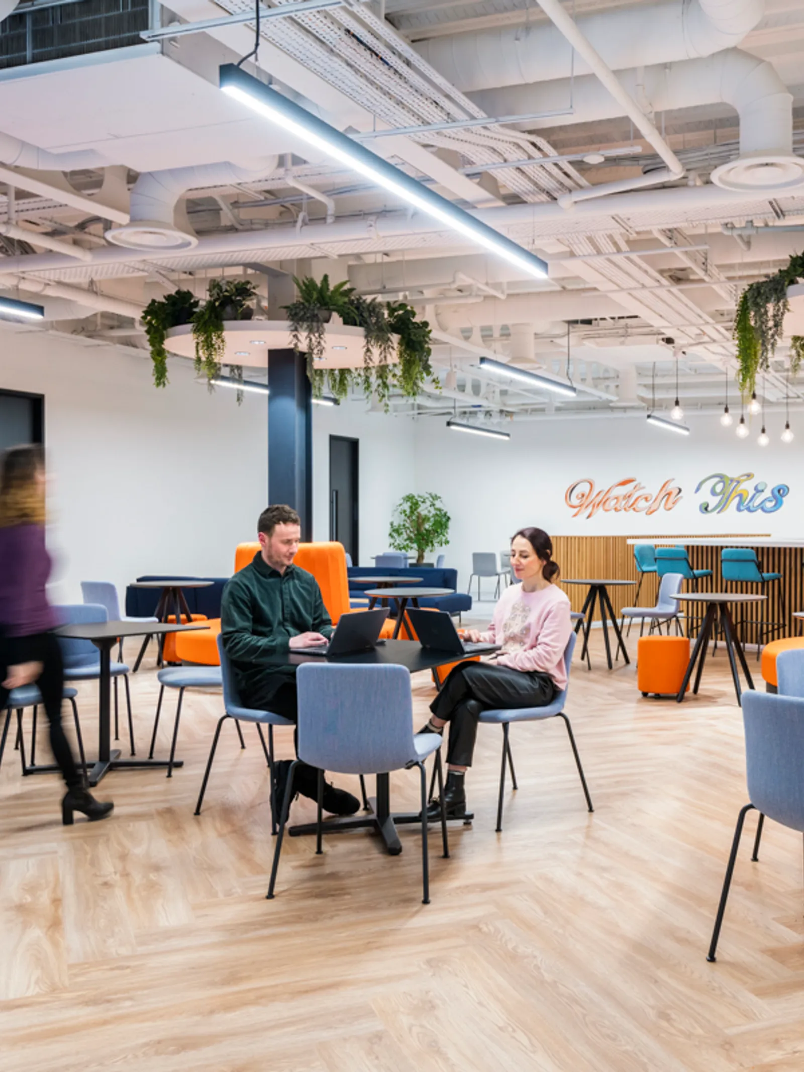 a newly designed hybrid office space with people working at tables