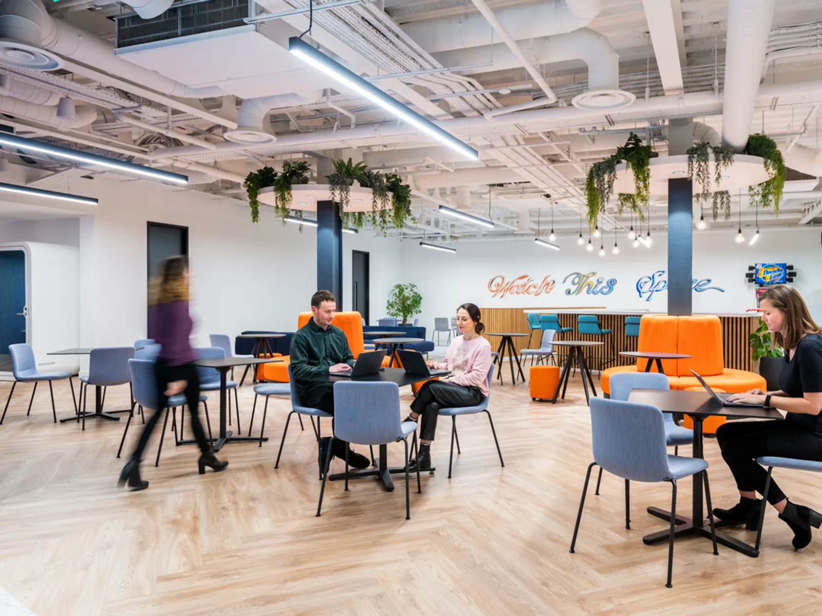 a newly designed hybrid office space with people working at tables