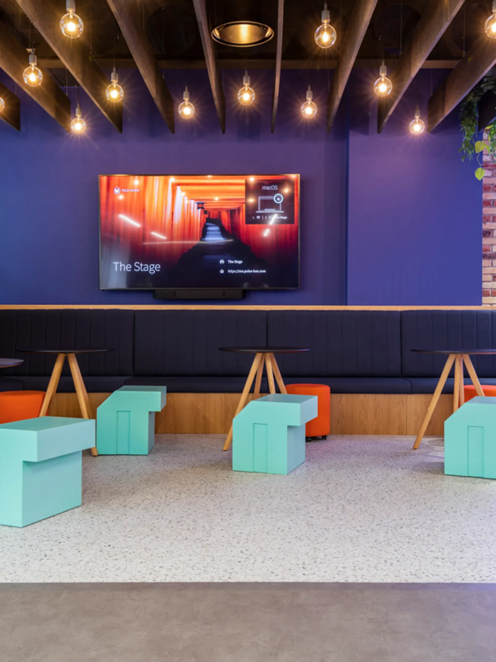 a seating area in a hybrid office space with tv and warm lighting