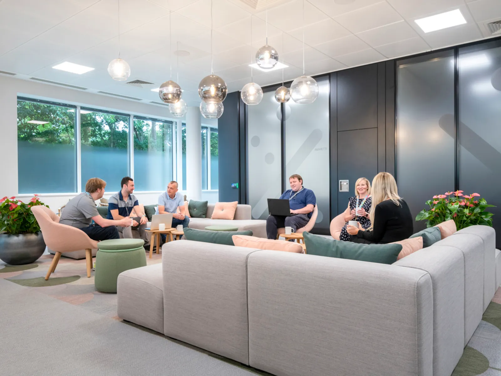 a newly designed office with people sitting on sofas