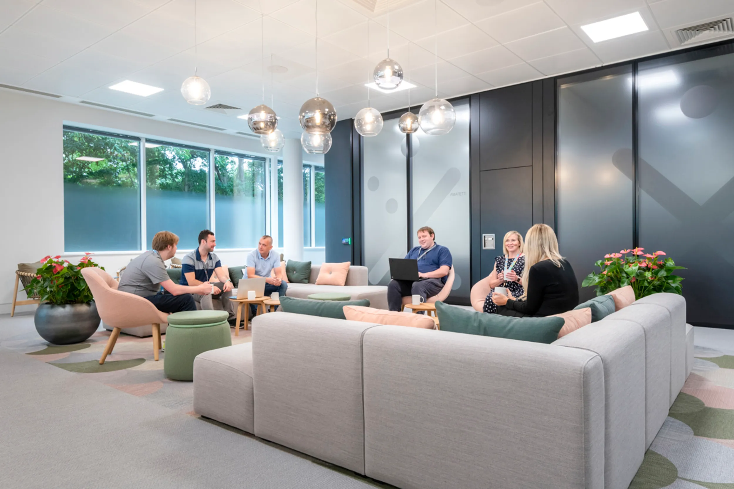 a newly designed office with people sitting on sofas