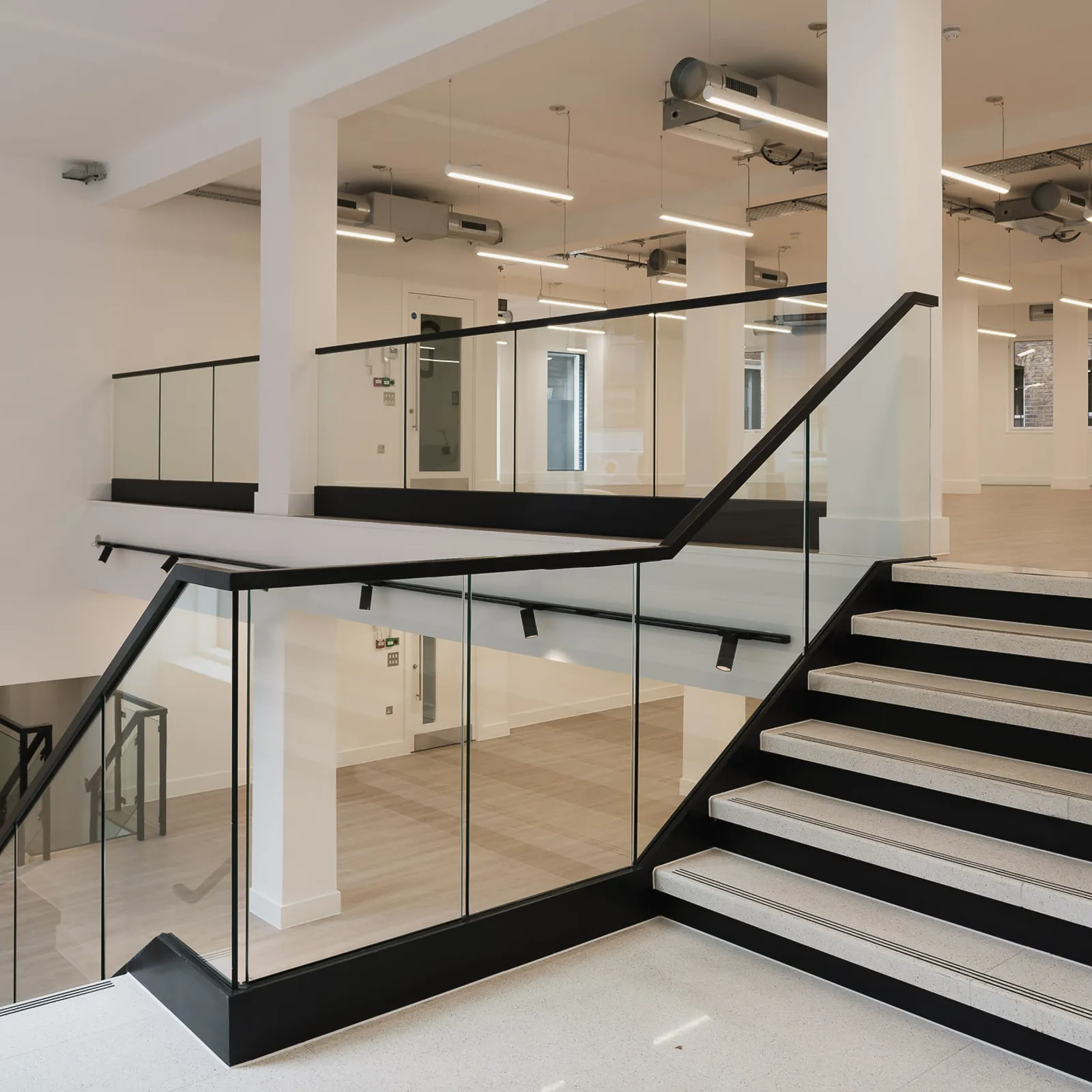 a cat a fit out showing a staircase with glass railings