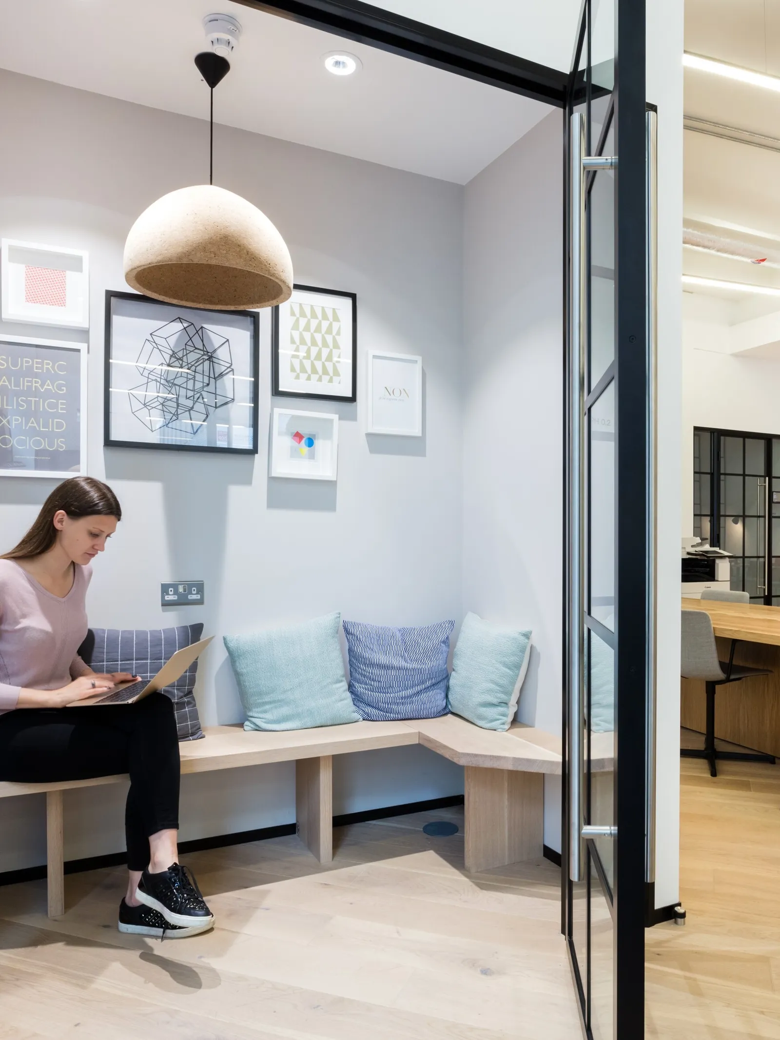 a person sitting in a modular office in an enclosed relaxed area