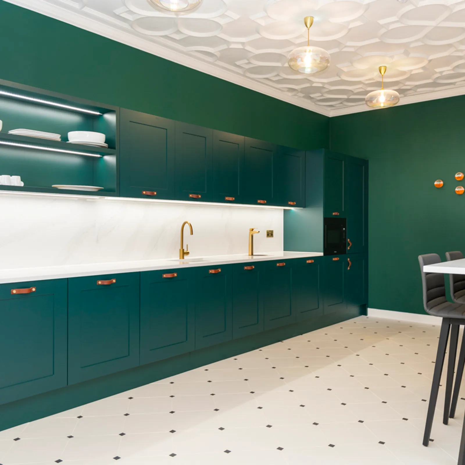 a kitchen area with high seats and green walls